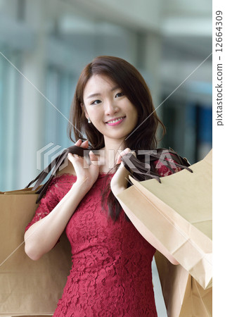One young pretty woman in red with shopping bags inside the mall One young pretty woman in red with shopping bags inside the mall 12664309