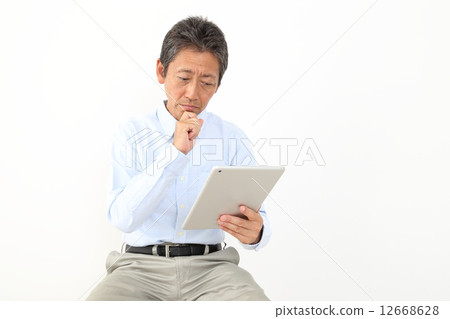 A man looking at a tablet A man looking at a tablet 12668628
