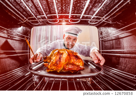 Cooking chicken in the oven. 12670858