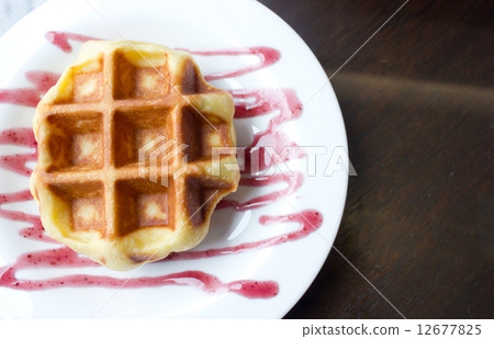 Close up of waffle on white plate with grape sauce. Close up of waffle on white plate with grape sauce. 12677825