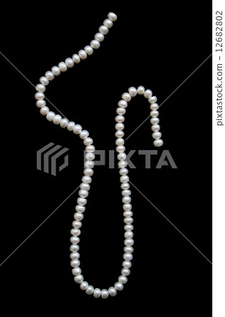 White pearls on a black velvet 12682802