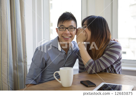 Two happy Chinese friends sharing secrets. Two happy Chinese friends sharing secrets. 12683875