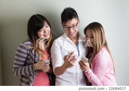 Happy Asian students using their cell phones. Happy Asian students using their cell phones. 12684017