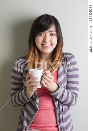 Asian woman standing on grey background Asian woman standing on grey background 12684021