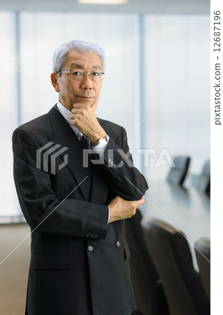 Senior CEO standing in the executive meeting room 12687196