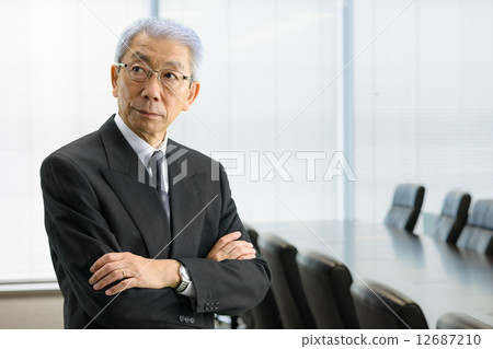 Senior CEO standing in the executive meeting room Senior CEO standing in the executive meeting room 12687210