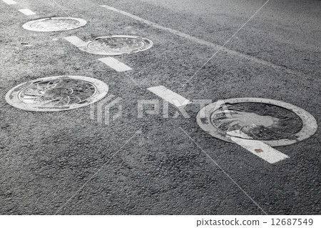 Sewer manholes on asphalt road pavement 12687549