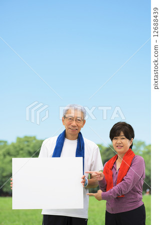 Senior couple having a whiteboard at a blue sky park 12688439