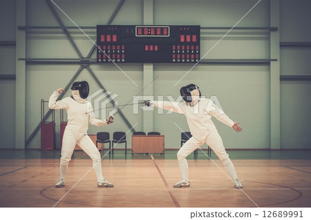 Two women fencers on a training 12689991