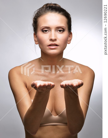 Beautiful woman in flesh color underwear showing by hand. 12690221