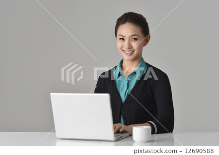 an confident asian office lady sitting in front of her desk an confident asian office lady sitting in front of her desk 12690588