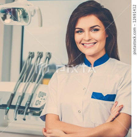 Young beautiful brunette female dentist at dentist's surgery 12691412
