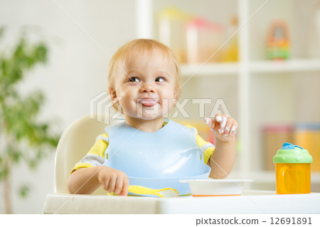 smiling baby kid boy eating itself with spoon smiling baby kid boy eating itself with spoon 12691891