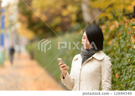 A woman watching a smartphone 12694340