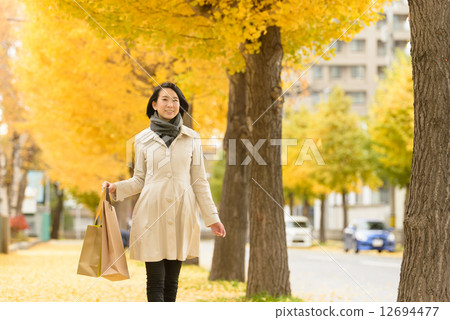A woman walking in ginkgo trees A woman walking in ginkgo trees 12694477