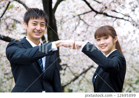 Men and women of suits in front of cherry blossoms Men and women of suits in front of cherry blossoms 12695899