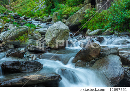 Cascade falls over mossy rocks 12697861
