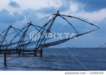 Chinese fishnets in twilight. Kochi, Kerala, India 12698359