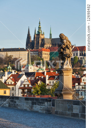 Statue on Charles Brigde against St. Vitus Cathedral in Prague 12698482