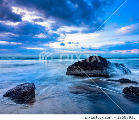 Waves and rocks on beach of sunset 12698933