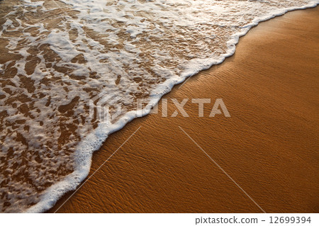 Wave surging on sand Wave surging on sand 12699394