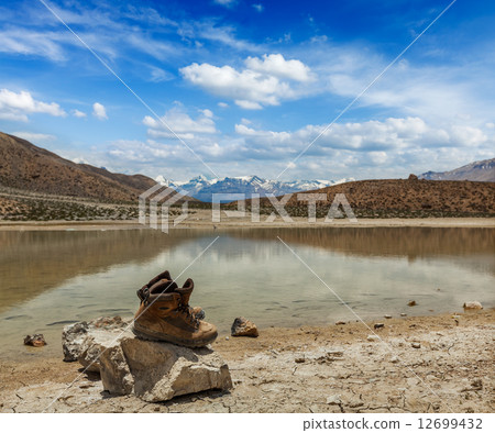 Trekking hiking boots at mountain lake in Himalayas 12699432