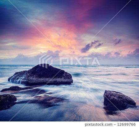 Waves and rocks on beach of sunset 12699766