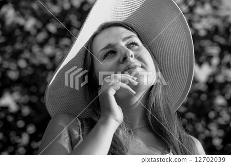 Monochrome portrait of elegant woman in white hat posing at gard Monochrome portrait of elegant woman in white hat posing at gard 12702039