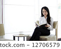 Attractive asian woman reading a book in the cafe. 12706579