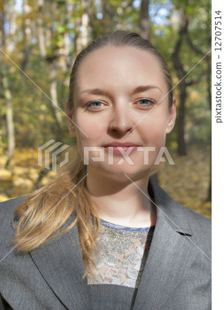 pretty young woman in a gray business dress standing 12707514