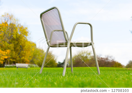 metal chair on a green lawn metal chair on a green lawn 12708103