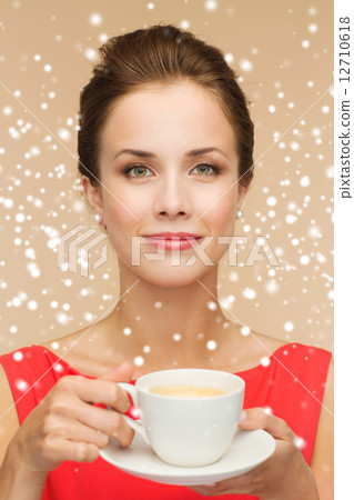 smiling woman in red dress with cup of coffee 12710618