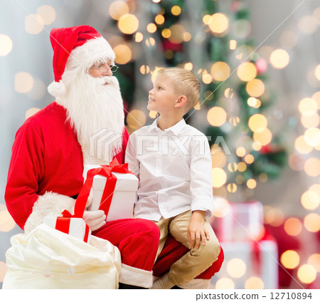 smiling little boy with santa claus and gifts smiling little boy with santa claus and gifts 12710894