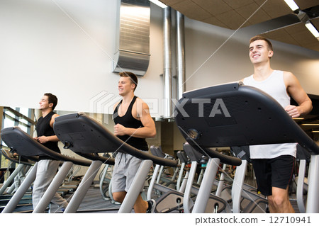 smiling men exercising on treadmill in gym smiling men exercising on treadmill in gym 12710941
