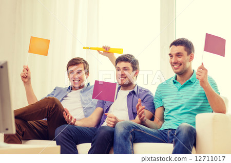 happy male friends with flags and vuvuzela happy male friends with flags and vuvuzela 12711017