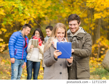 group of smiling friends with tablets in park group of smiling friends with tablets in park 12711295
