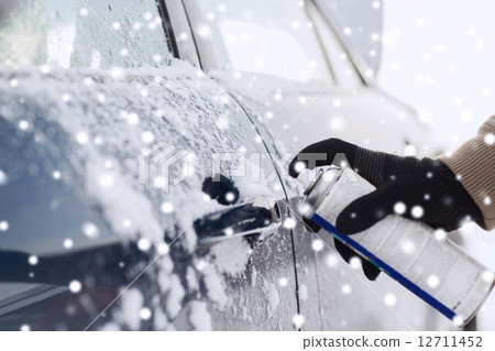 closeup of man hand with lock door de-icer 12711452