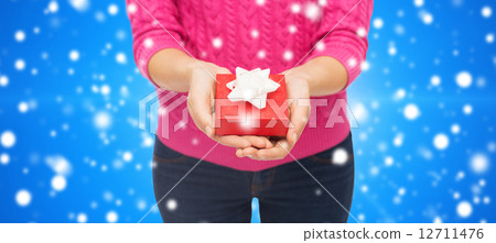 close up of woman in pink sweater holding gift box close up of woman in pink sweater holding gift box 12711476
