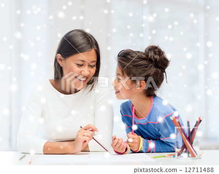 mother and daughter with coloring pencils indoors 12711488