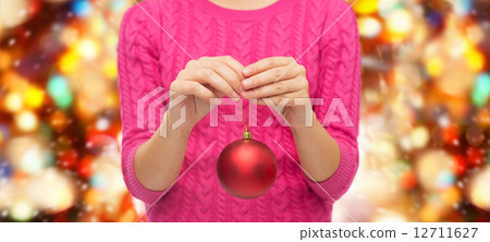 close up of woman in sweater with christmas ball 12711627