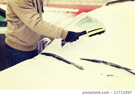 closeup of man cleaning snow from car 12712097