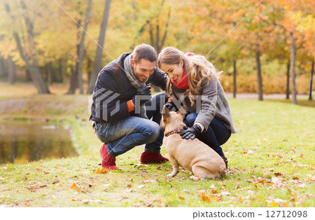 smiling couple with dog in autumn park smiling couple with dog in autumn park 12712098