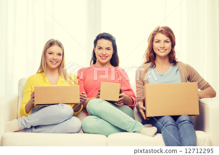 smiling teenage girls with cardboard boxes at home 12712295