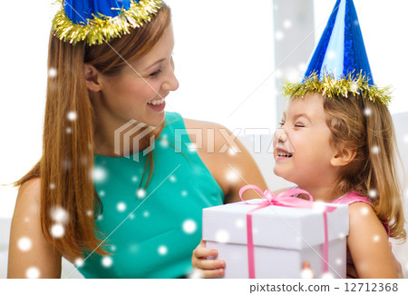 mother and daughter in party hats with gift box mother and daughter in party hats with gift box 12712368