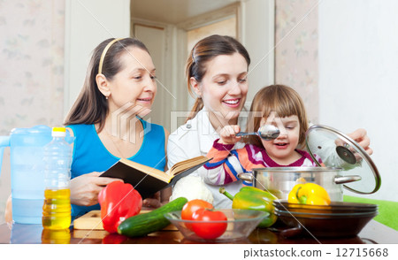 Happy family together cook with cookbook Happy family together cook with cookbook 12715668