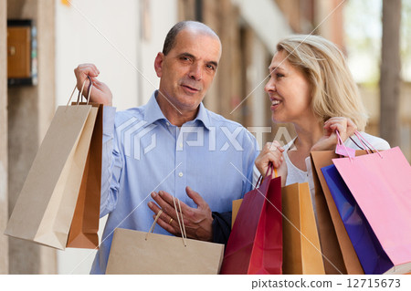 Aged couple with purchases 12715673