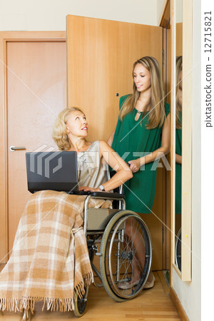 Happy woman in wheelchair working on laptop Happy woman in wheelchair working on laptop 12715821