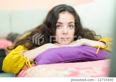 Upset girl on sofa at home 12715840