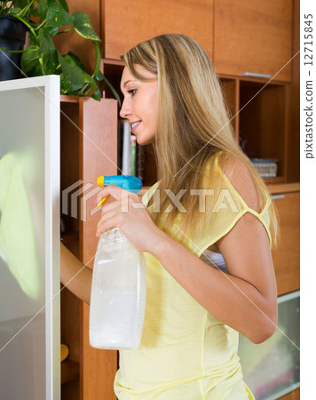 Blonde girl cleaning glass door of furniture Blonde girl cleaning glass door of furniture 12715845