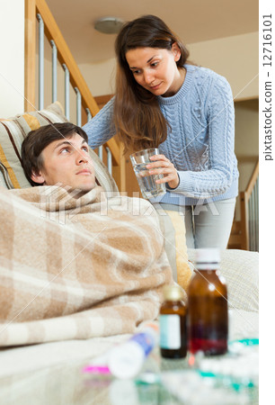 girl caring for sick husband in living room 12716101